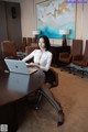 A woman sitting at a table with a laptop computer.