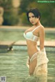 A woman in a white lingerie standing in a pool.