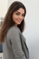 A woman in a gray blazer posing for a picture.