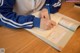 A person sitting at a table writing in a notebook.