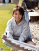 A woman sitting in a hammock smiling at the camera.