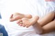 A close up of a person's feet on a bed.