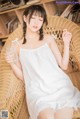 a woman sitting in a wicker chair holding a glass of water