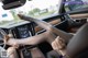 A woman sitting in the driver's seat of a car with her legs up.