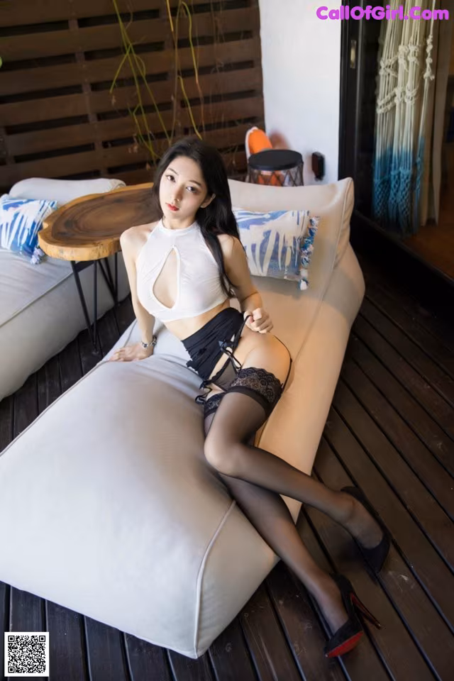 A woman sitting on top of a white couch.