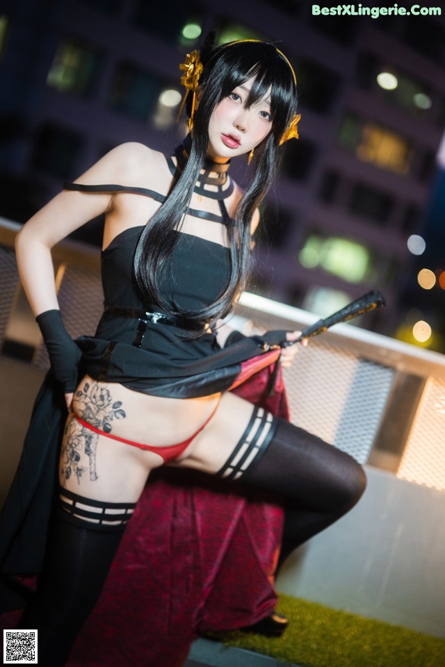 A woman in a black dress holding a sword.